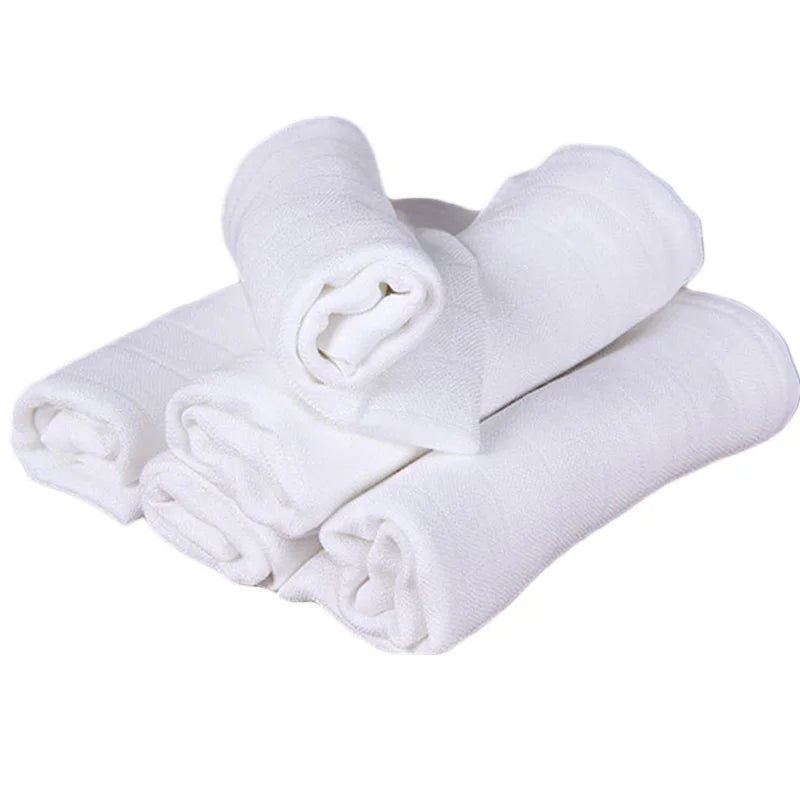 Une pile de serviettes Langes Couvertures & Couches Bébé en Coton soigneusement roulées pour enfant prématuré sur fond clair. (BÉBÉ PREMA)