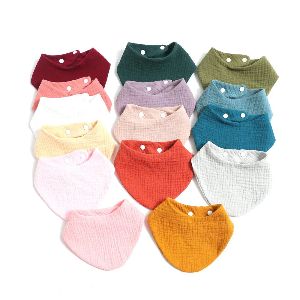 Un assortiment coloré de Bavoir 100% Coton pour Bébés de BABY PREMA, disposés en cercle, présentant une variété de couleurs et de textures unies.
