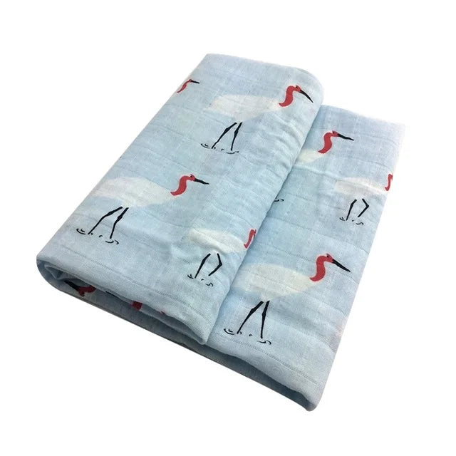 Tissu plié bleu clair à motifs de flamants roses sur fond blanc, créé pour prématuré bébé par BABY PREMA, la Lange Bébé en Coton et Fibre de Bambou.