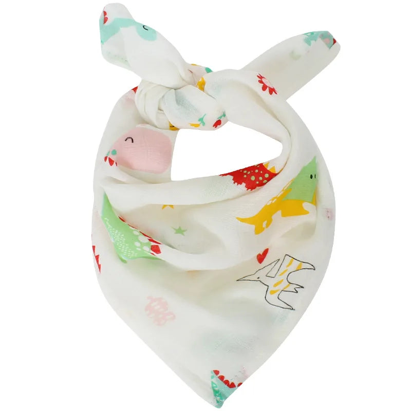 Un bandana blanc fantaisiste orné de dinosaures colorés et de motifs ludiques de bébé dodo, noué en haut pour une touche de style - Lange Mousseline Coton Bio de BABY PREMA | Emmaillotage de Bébé.