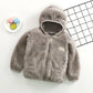 Manteau Gilet pour bébé confortable pour tout-petit de BABY PREMA en sweat à capuche en fausse fourrure grise sur une surface blanche avec une assiette colorée de citrons verts à proximité, présentant un vêtement d'hiver pour enfants ludique mais chaud pour prématuré.