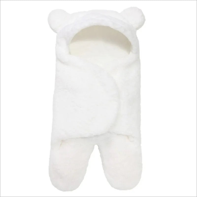 Un porte-bébé blanc en peluche avec des oreilles d'ours sur la capuche, parfait comme couverture bébé Nid D'Ange de BABY-PREMA.