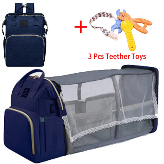 Un sac à dos à langer multifonctionnel Baby Prema Sac à Langer Bébé Bleu Marine avec un berceau portable intégré, accompagné d'un ensemble de trois jouets de dentition pour bébés.