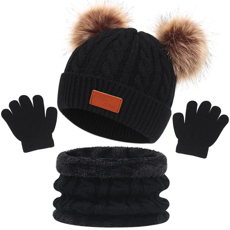 Un ensemble d'accessoires d'hiver comprenant un BABY PREMA Ensemble 3Pièces Bonnet Gants pour Bébé avec deux pompons marron pour un bébé prématuré, une paire de gants légers noirs et un cache-cou noir, le tout.