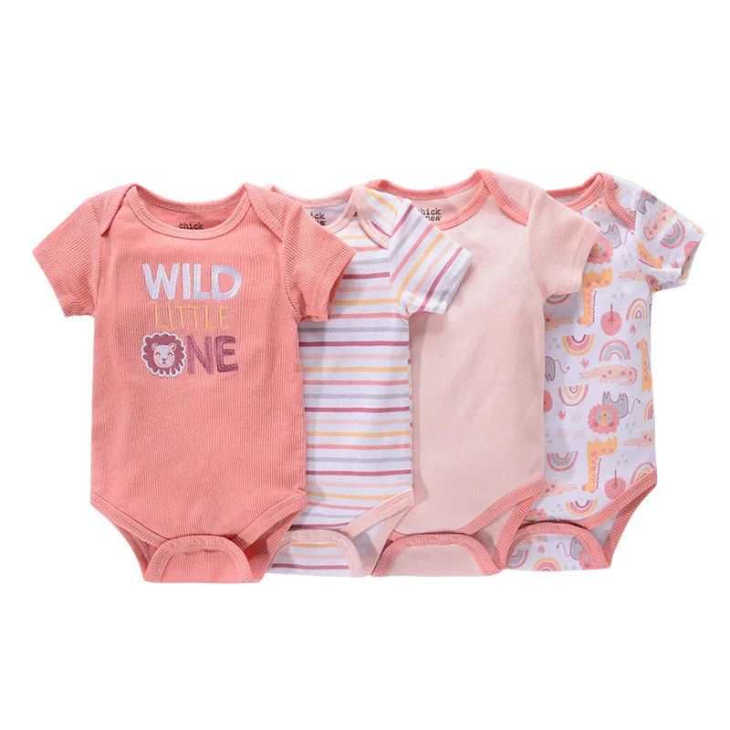 Quatre grenouillères pour bébé sont disposées côte à côte. Ils comprennent une combinaison rose avec le texte « WILD LITTLE ONE », une à rayures, une rose unie et une à motifs avec des arcs-en-ciel et des animaux. Ce **Lot de 4 Bodies Coton Bébé Couleurs été** est confectionné en **BABY PREMA**, parfait pour le confort de votre tout-petit pendant l'été.