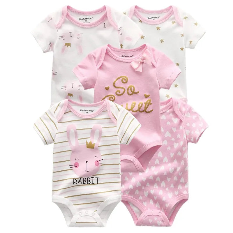 Cinq BABY PREMA Lot de 5 Pièces 100% Coton pour Bébé à manches courtes disposées sur deux rangs. Les bodys pour bébés présentent divers motifs, notamment des lapins, des cœurs, des étoiles et la phrase « So Sweet », dans des tons de blanc, de rose et d'or. Fabriqué en coton doux pour plus de douceur.