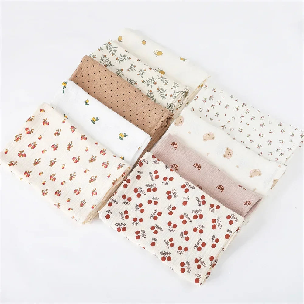 Une collection de Couverture Emmaillotage soigneusement pliées | en coton pour Bébé avec divers motifs pittoresques et charmants pour l'hygiène de bébé sur fond blanc par BABY PREMA.