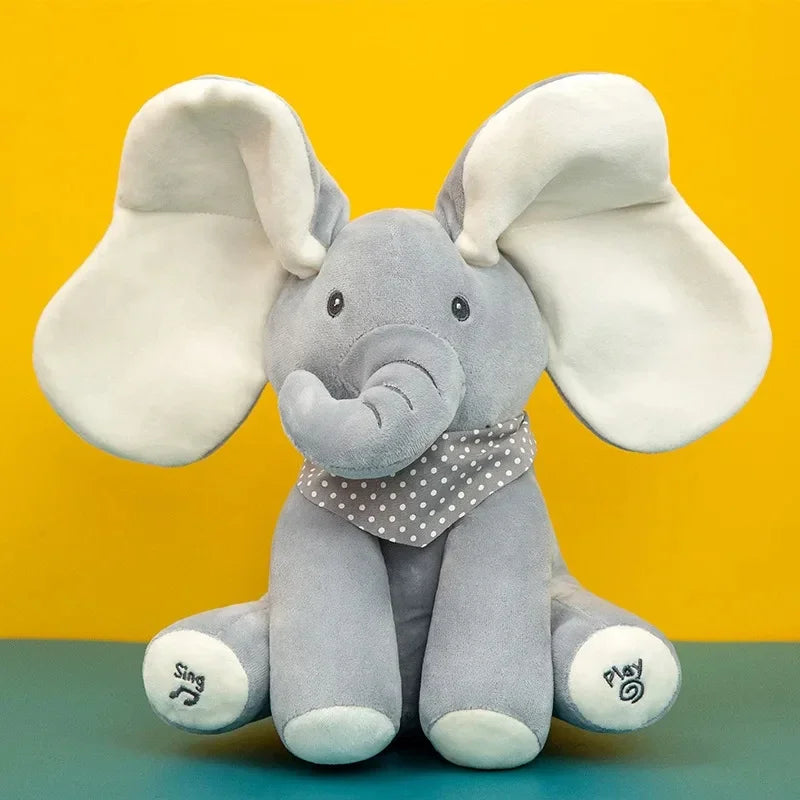 Un éléphant en peluche douce avec de grandes oreilles et une écharpe à pois sur fond jaune et vert, parfait pour un bébé.
Jouet éléphant en peluche | chantant avec Oreilles Mobiles par BABY-PREMA.