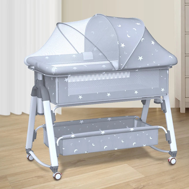 Un Lit Bébé Multifonction Pliant Baby PREMA moderne et portable avec un auvent à motif étoilé et des côtés en filet sur roulettes, doté d'une étagère de rangement inférieure, conçu pour la sécurité et la commodité du bébé à la maison.