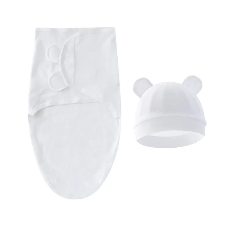 Une paire de moufles pour bébé prématurément blancs et un bonnet assorti avec des détails oreilles sur un fond blanc. BABY PREMA Ensemble Gigoteuse Couverture Ajustable | 100% Coton Pour Bébé.