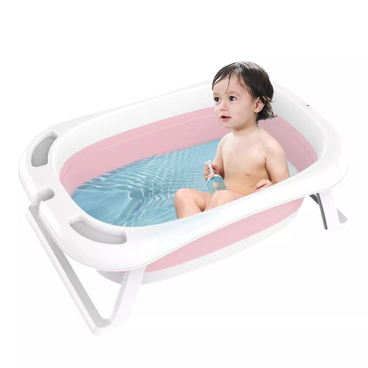 Un bambin profite d'un bain ludique dans une Baignoire Pliable pour Bébé portable BABY PREMA, rose et blanche, entouré de tout le nécessaire pour bébé pour assurer une hygiène impeccable de bébé.