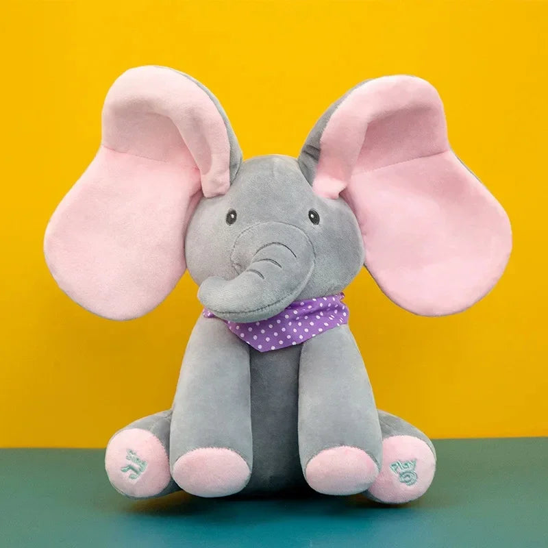Un joli Doudou Eléphant Peluche Musicale avec des oreilles roses surdimensionnées et une écharpe violette à pois, posé sur un fond jaune et bleu, est parfait pour un bébé de BABY-PREMA.