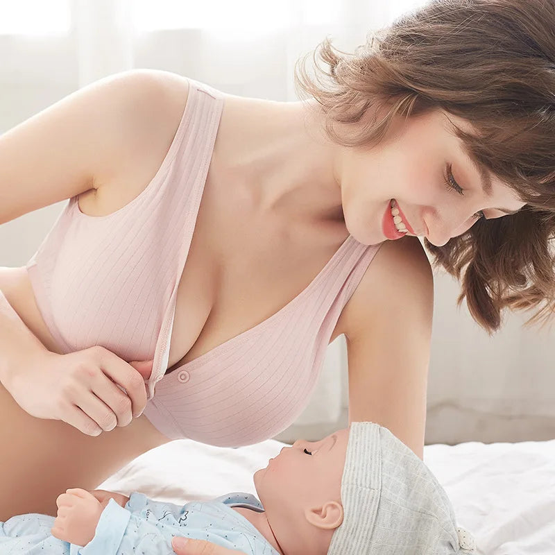 Une femme souriante dans un BABY PREMA Soutien D'Allaitement Confortable interagit tendrement avec son bébé heureux dans une pièce confortable et ensoleillée. Le petit bébé rit doucement, se sentant aussi léger qu'une plume poids léger.