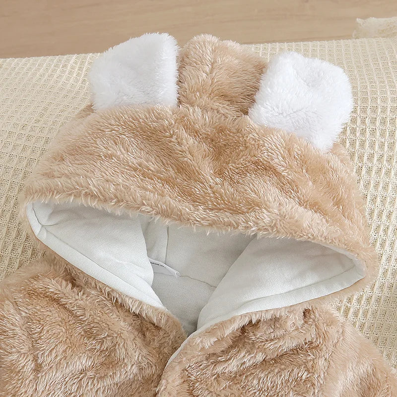 Gros plan d'un sweat à capuche beige à oreilles de lapin BABY-PREMA avec doublure intérieure blanche affiché sur un fond beige tissé. La capuche est ornée de trois oreilles de lapin blanches douces, conçues pour un confort haut de gamme.