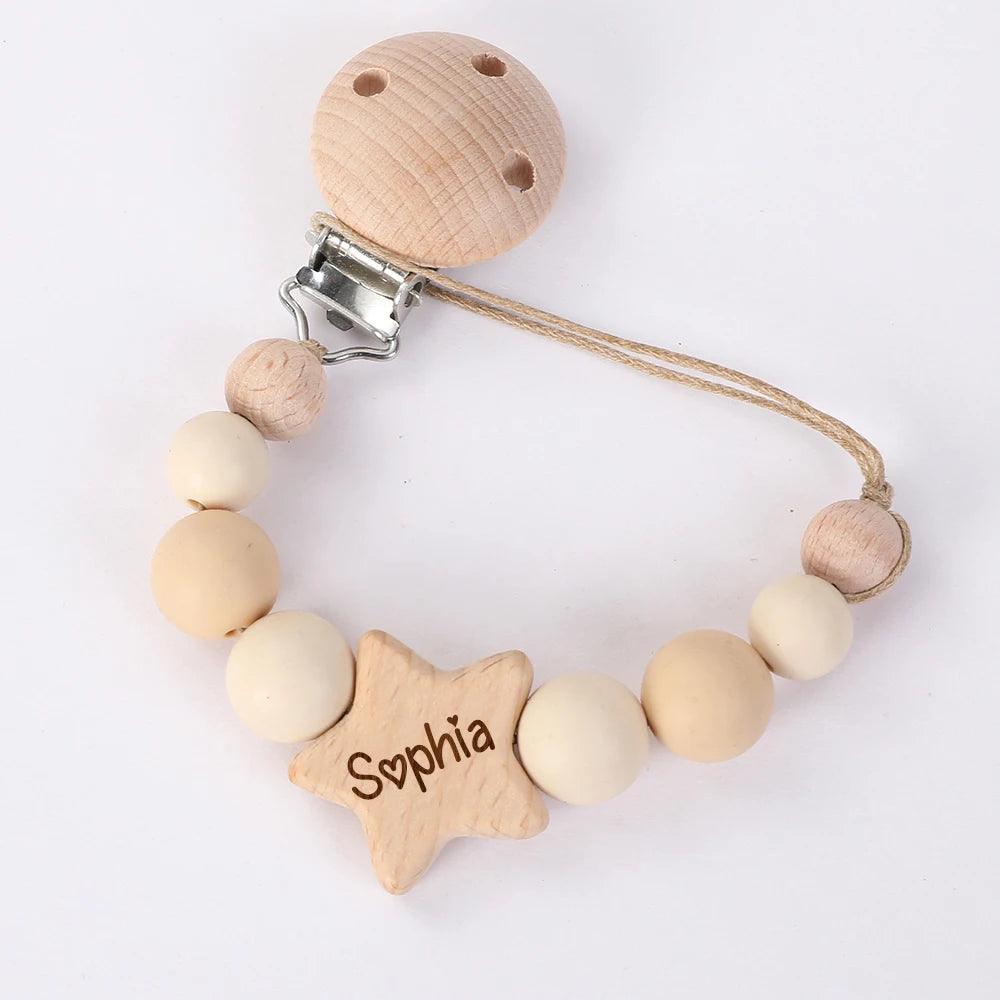 Un accessoire bébé personnalisé : un attache-sucette bébé personnalisé BABY-PREMA avec le nom "sophia" gravé sur une perle en forme d'étoile, flanquée