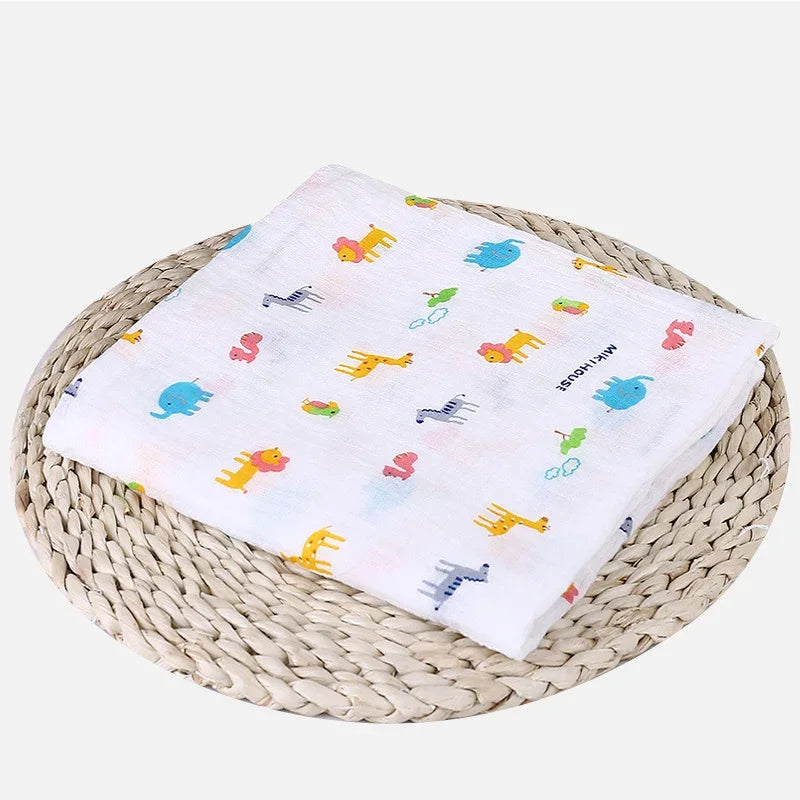 Une couverture colorée pour bébé avec des motifs d'animaux et de jouets pliés soigneusement sur un tapis tissé circulaire.