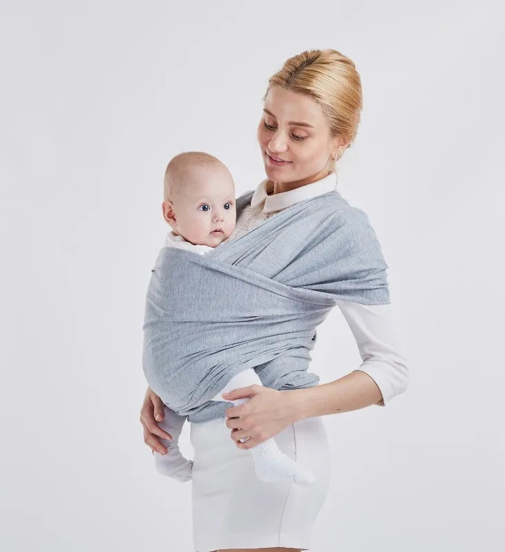 Une mère portant avec amour son bébé prématuré dans une Écharpe de Portage de Bébé Confortable & Doux BABY PREMA sur fond blanc.