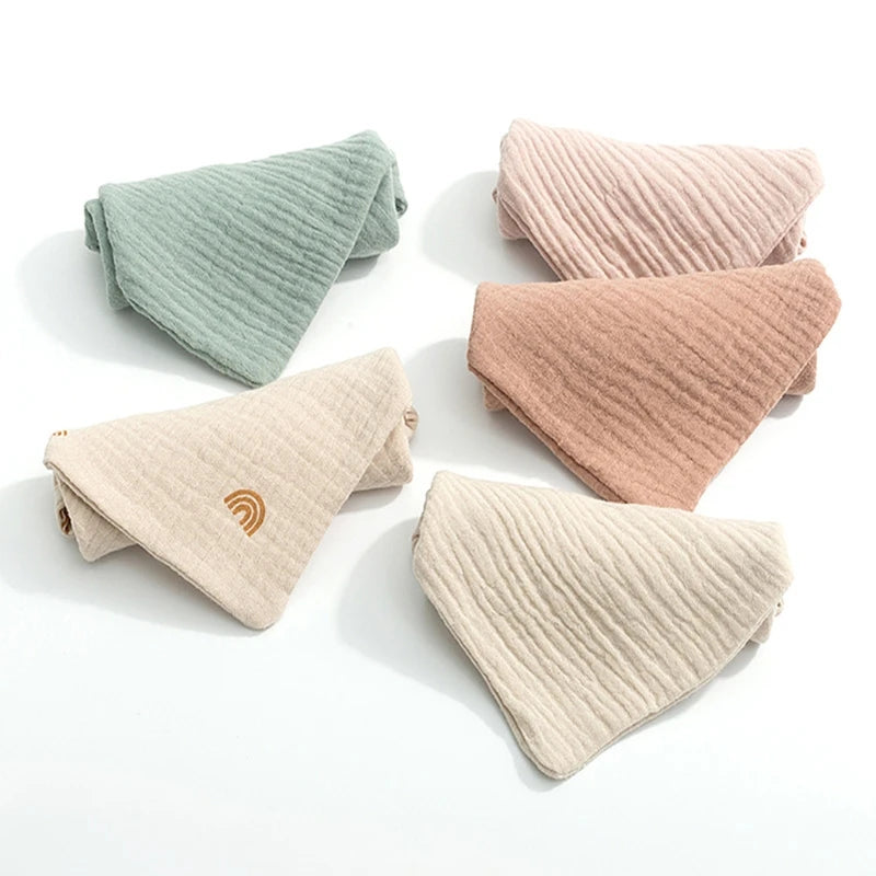 Une collection de pochettes triangulaires BABY PREMA élégantes aux couleurs pastel, conçues pour bébé, soigneusement disposées sur un fond blanc.