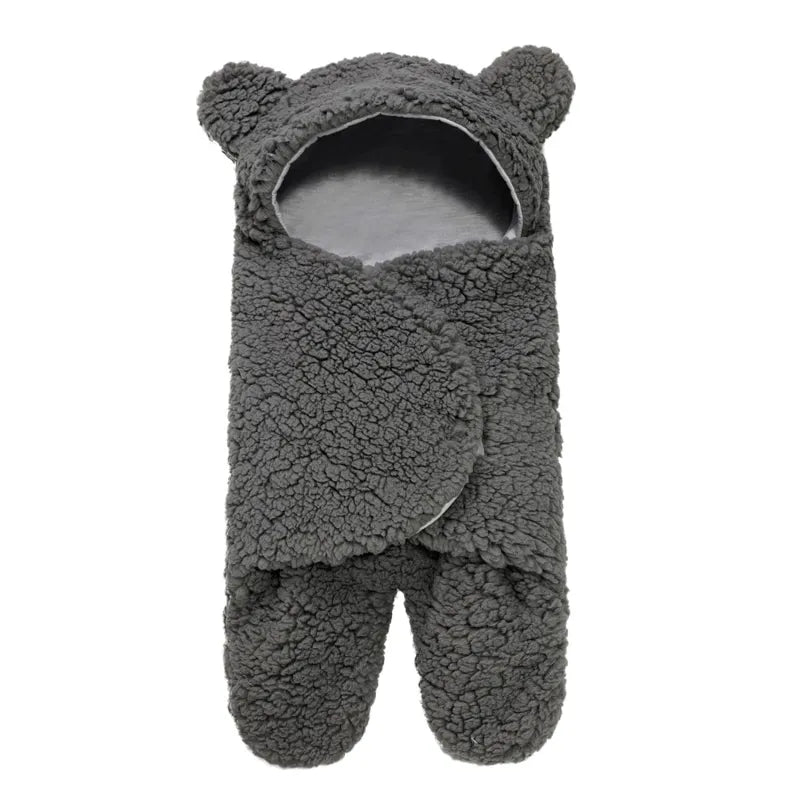 Une couverture Cocon pour bébé en forme d'ours en peluche pour bain bébé, dotée d'une capuche avec des oreilles d'ours.