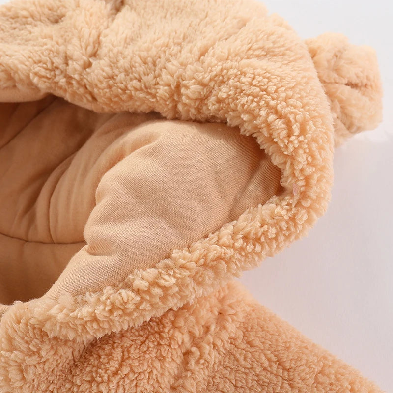 Gros plan d'un tissu en peluche doux et pelucheux de couleur marron clair utilisé dans une Barboteuse à Capuche Combinaison Epaisse Bébé BABY-PREMA pour bébés, montrant la texture et les détails de la doublure intérieure.