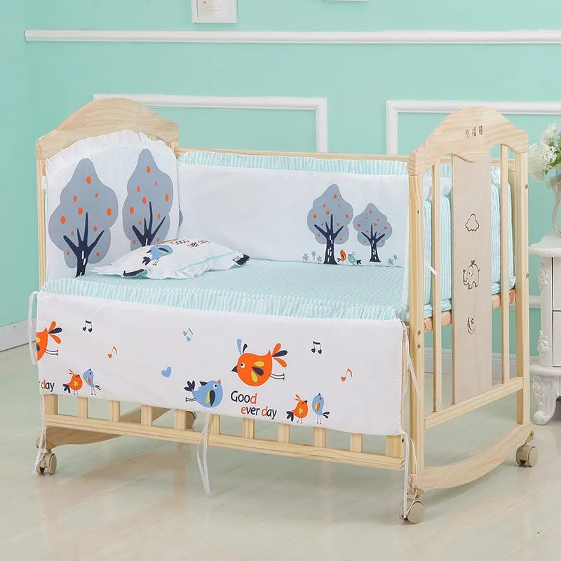 Une chambre de bébé colorée et joyeuse avec un berceau en bois BABY PREMA orné de l'Ensemble 5 Pièces Literie Bébé en Coton aux motifs ludiques de poissons et d'arbres, parfait pour votre bébé.