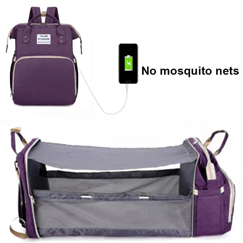 Lit bébé portable avec fonction de chargement USB, conçu pour « mon bébé », transformable en sac à dos pour faciliter les déplacements et fabriqué sans moustiquaire : le Sac à Langer Bébé Violet 3 en 1 USB de BABY PREMA.