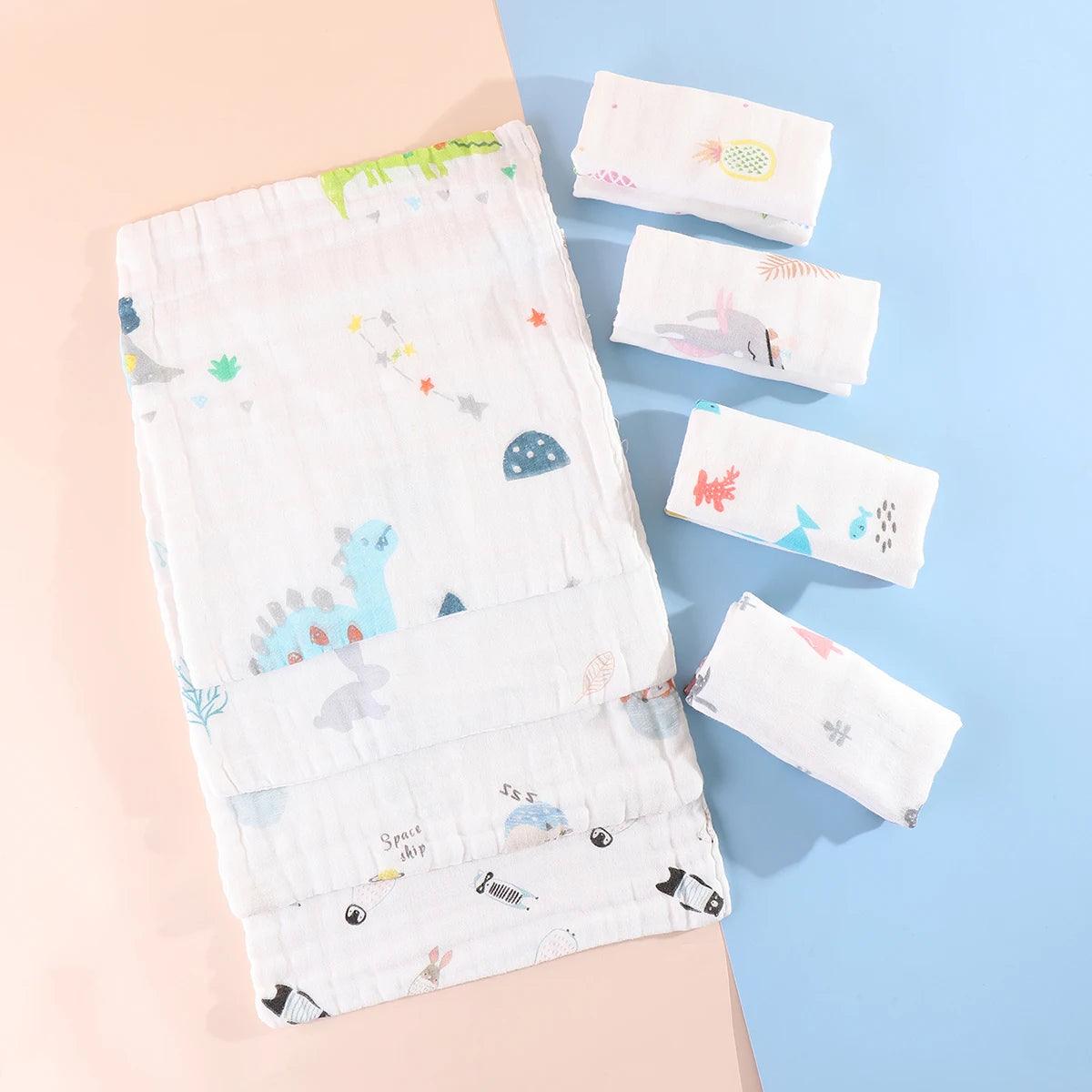 Une collection de 5 Langes Coton Mousseline pour Bébé de BABY-PREMA sur le thème ludique des dinosaures et de l'espace, soigneusement disposés sur un fond pastel.