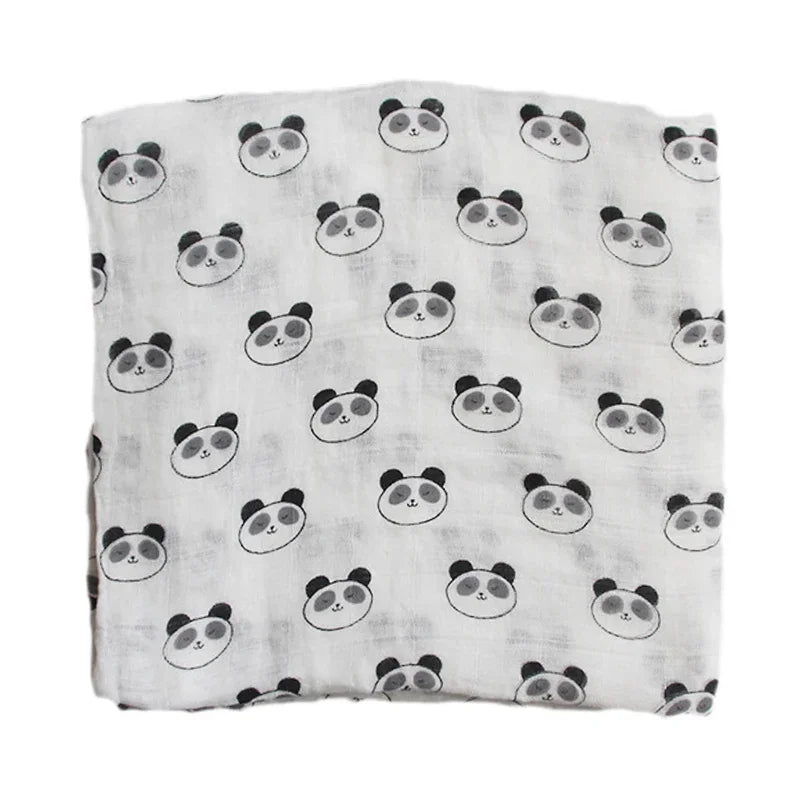 Une douce couverture en mousseline de coton pour bébé, ornée d'un motif de visages de panda dessinés, dans un simple jeu de couleurs noir et blanc, idéale pour des accessoires bébé BABY PREMA.