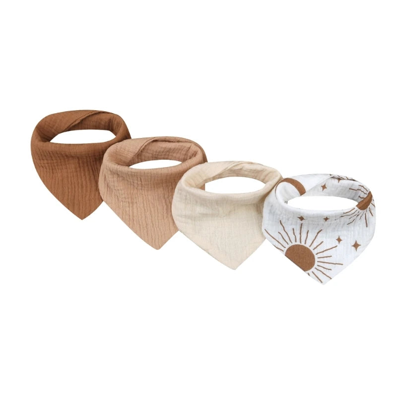 Quatre bavoirs bandana bébé aux tons terreux sont exposés côte à côte. Ce lot de 4 bavoirs Bavoirs en mousseline coton pour bébé de BABY-PREMA comprend un en marron, un en beige, un en crème clair et un en blanc avec un motif soleil et étoile. Chaque bavoir est confectionné en mousseline de coton douce pour un confort ultime.