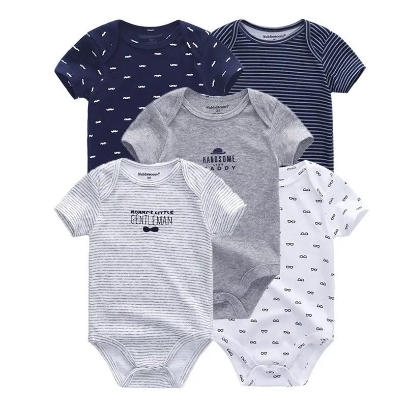 Cinq grenouillères pour bébé de différents motifs et couleurs, dont bleu marine, gris et blanc, disposées en forme d'éventail. Ce Lot de 5 Pièces 100% Coton pour Bébé de BABY PREMA présente des textes et des petits motifs imprimés comme des lunettes et des rayures, le tout en coton doux avec des manches courtes pour un confort ultime.