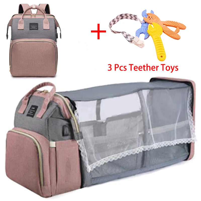 Un sac à langer BABY PREMA Sac à Langer Bébé Bleu 3 en 1 avec un berceau portable associé à un lot de trois jouets de dentition.