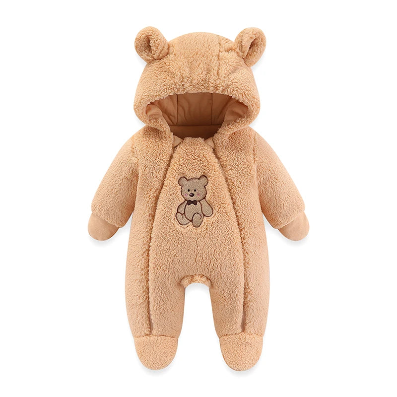 Barboteuse à Capuche BABY-PREMA en peluche couleur brun clair avec capuche conçue pour ressembler à une tête d'ours, ornée de petites oreilles. La combinaison...