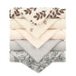 Une pile de serviettes pliées soigneusement disposées avec des motifs variés dans des tons terreux, toutes fabriquées à partir du tissu Lot de 5 Langes Bébé en Coton de BABY PREMA.