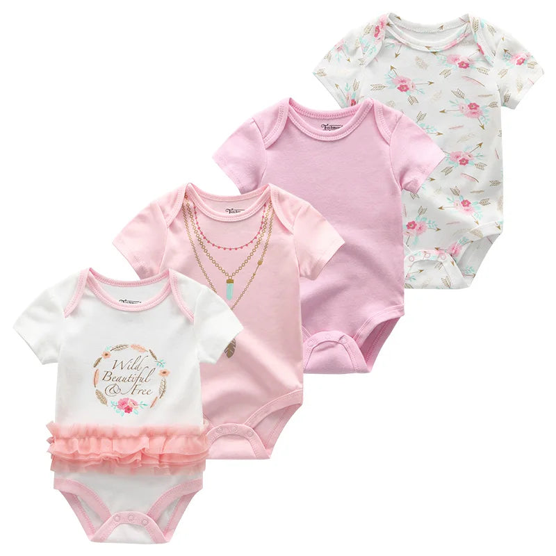 Quatre bodys bébé sont présentés dans la collection. De gauche à droite : un motif blanc « Wild, Beautiful & Free » avec un tutu rose, un body rose à imprimé collier, un body rose uni et un body à imprimé fleuri. Ce Lot de 4 Bodies Coton Bébé Couleurs été de BABY PREMA est confectionné en coton doux, parfait pour le confort d'été.