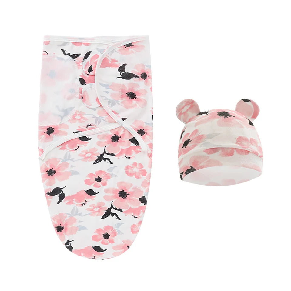 Une couverture de swaddle pour bébé et un bonnet assorti avec un design floral rose et des accents noirs, comportant de petites oreilles sur le bonnet pour une touche BABY PREMA.