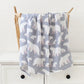 Un charmant accessoire pour bébé avec un motif d'ours polaire blanc drapé sur une chaise en bois, ajoutant une touche cosy à une chambre de bébé est la Couverture Bébé en Coton et Bambou Bio de BABY PREMA.