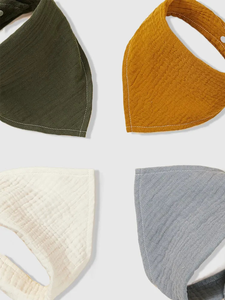 Quatre masques bandanas Bavoirs Coton Bio de couleurs différentes disposés en quadrant, présentant diverses textures et nuances pour des vêtements de protection, adaptés comme accessoires de BABY PREMA.