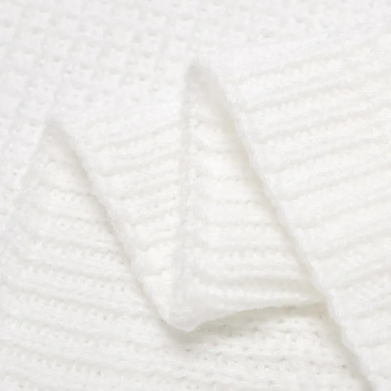 Gros plan d'un tissu blanc texturé soigneusement plié avec un motif côtelé visible, ressemblant à une Couverture Bébé Tricot Fin 90*70 cm - Baby-Prema parfaite pour toutes les saisons.