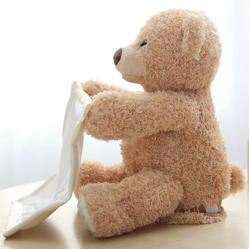 Une peluche Doudou Ours Musical "Peekaboo" de BABY PREMA assis et semblant tenir ou examiner un tissu ou un mouchoir blanc léger.