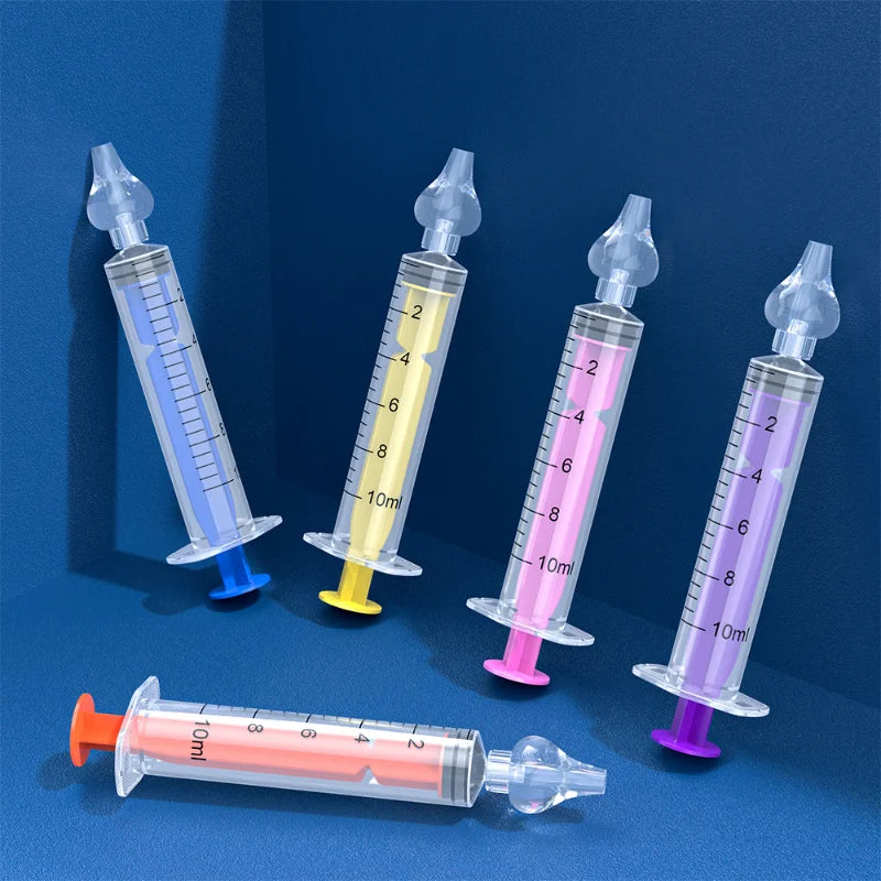 Cinq seringues colorées sans aiguilles, chacune avec un piston de couleur différente et des mesures sur le côté, debout à l'aide de supports légers attachés sur un fond bleu bicolore, comme le Lot 2 Pièces Nettoyant Nasal pour Bébé de BABY-PREMA.