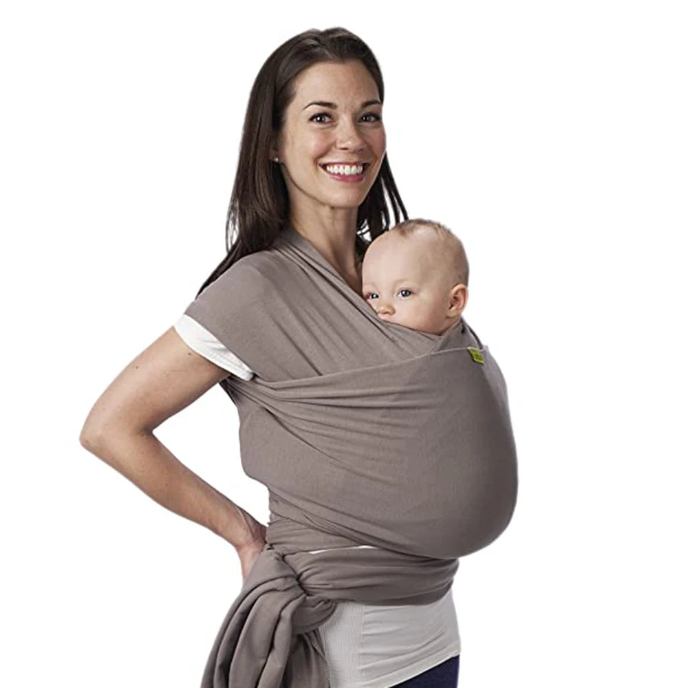 Une femme souriante portant un bébé prématuré dans une BABY PREMA Echarpe de Portage de Bébé Confortable & Doux.