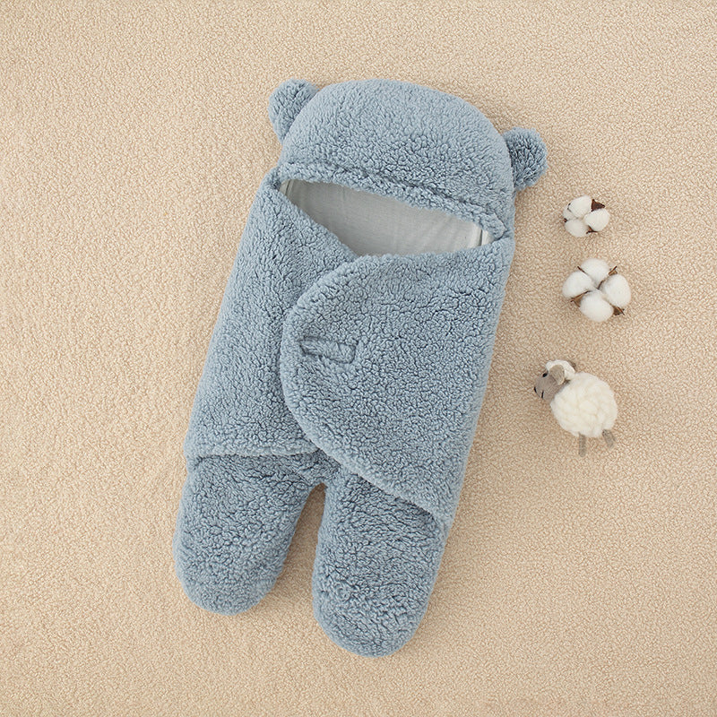 Une gigoteuse bébé toute douce en forme d'ours bleu posée sur un fond beige, accompagnée de fleurs en coton et d'un petit mouton en peluche. Cet article indispensable pour bébé apporte du confort pendant le sommeil de bébé.
Produit : BABY PREMA Couverture épaisse douce bébé