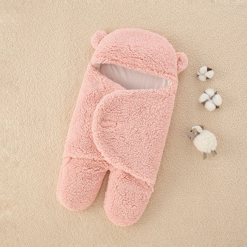 Une paire de chaussons ours roses et moelleux posés sur une surface beige douce, accompagnés de quelques cotonniers décoratifs et d'un petit mouton en peluche, évoquant une atmosphère chaleureuse et confortable pour les soins de bébé avec la Couverture épaisse douce bébé de BABY PREMA.