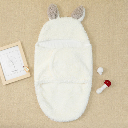 Accompagnée d'un cadre décoratif et de jouets hochets sur un fond beige doux, cette gigoteuse douillette pour bébé a la forme d'un animal fantaisiste avec de jolies oreilles, parfaite comme une BABY PREMA Cocon Couverture bébé.