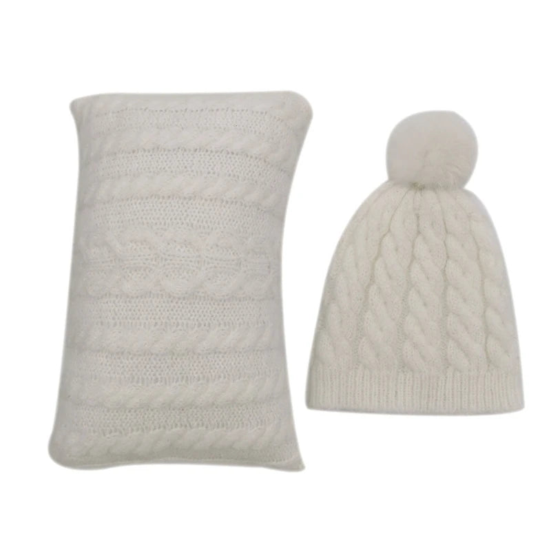 Un ensemble tricoté blanc douillet Cadeau Naissance Bébé | Oreiller 2 pièces pour Bébé et un bonnet assorti avec un petit pompon sur fond blanc.