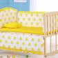 Une chambre d'enfant joyeuse avec une confortable combinaison berceau-canapé convertible, avec une literie jaune vif ornée d'un motif de couronne ludique, dans un intérieur bleu apaisant. L'Ensemble 5 Pièces Literie Bébé en Coton BABY PREMA est parfait pour bébé dodo.