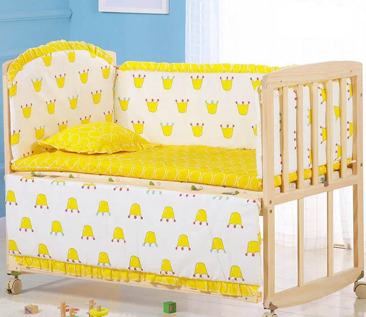 Une chambre d'enfant joyeuse avec une confortable combinaison berceau-canapé convertible, avec une literie jaune vif ornée d'un motif de couronne ludique, dans un intérieur bleu apaisant. L'Ensemble 5 Pièces Literie Bébé en Coton BABY PREMA est parfait pour bébé dodo.