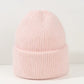 Une douce Bonnet Angora Pour Maman en tricot tricoté rose pâle conçu comme accessoire bébé, avec un revers plié présenté sur un fond neutre de la marque BABY PREMA.