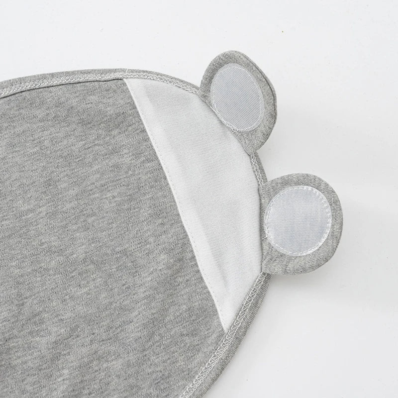 Un tapis de souris Gigoteuse Ajustable Coton pour Bébé en tissu gris avec repose-poignets intégrés conçus pour ressembler à des oreilles de souris, offrant le confort BABY PREMA.