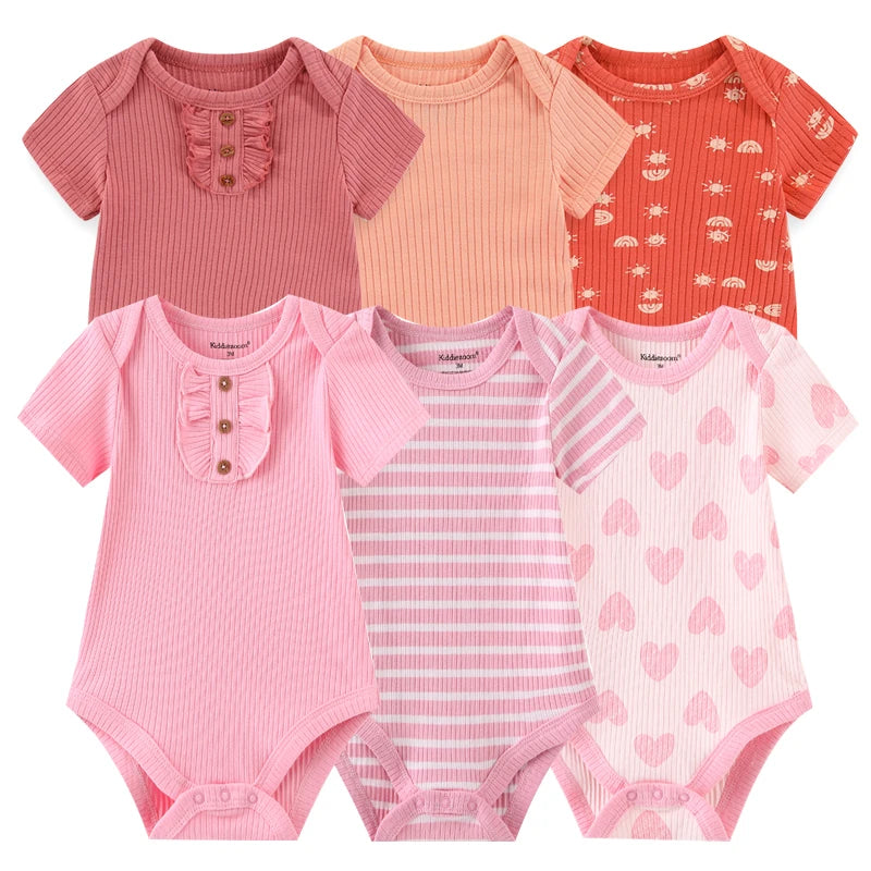 Six grenouillères pour bébé regroupées, chacune avec des motifs et des nuances de rose différents, avec des rayures, des cœurs, des couleurs unies et des petits volants. Ces adorables Lot 6 Body Coton Bébé Manches Courtes de BABY PREMA sont parfaits pour le confort et le style de votre bébé.